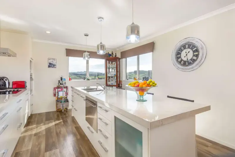 Kitchen with stone island bench and rural outlook
